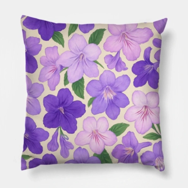 Two streptocarpus cape primrose floral pillows styled symmetrically on a light gray luxury sofa